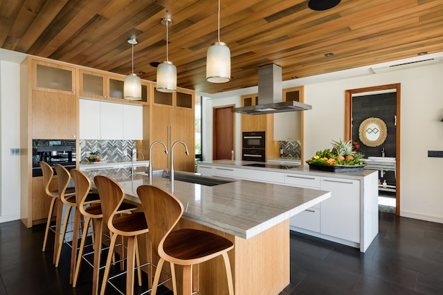 kitchen with decorative light fixtures, wooden ceiling, a center island with sink, island range hood, and backsplash