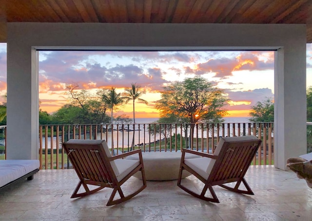 patio terrace at dusk with a balcony and a water view