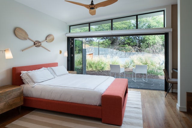 bedroom featuring access to exterior, ceiling fan, wood-type flooring, and vaulted ceiling