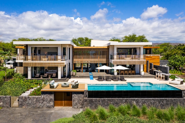 rear view of property featuring a balcony and a patio area