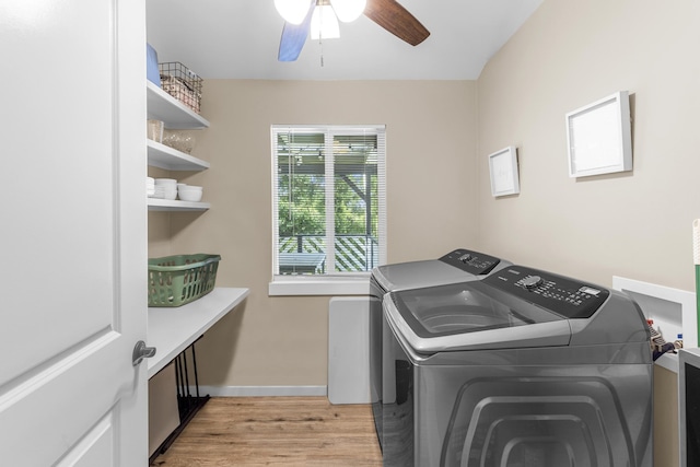 clothes washing area with washing machine and dryer, light hardwood / wood-style floors, and ceiling fan