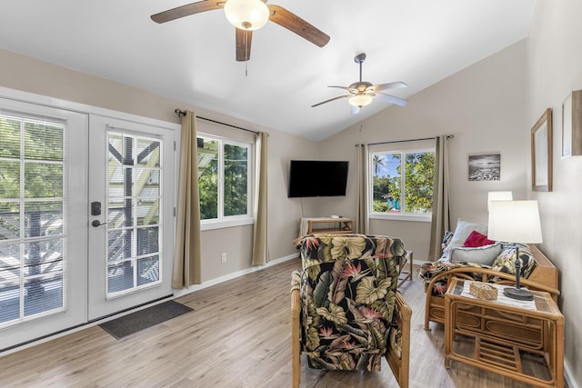 living room featuring french doors, vaulted ceiling, a wealth of natural light, and light hardwood / wood-style flooring