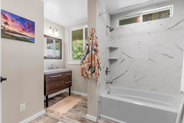 bathroom with tiled shower / bath and vanity