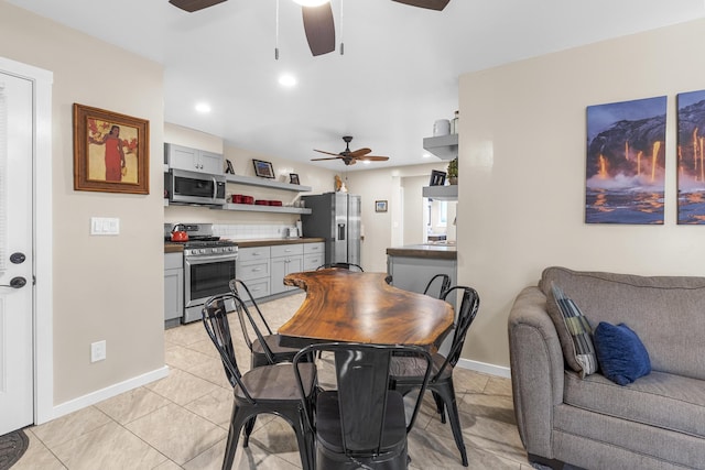 tiled dining space featuring ceiling fan