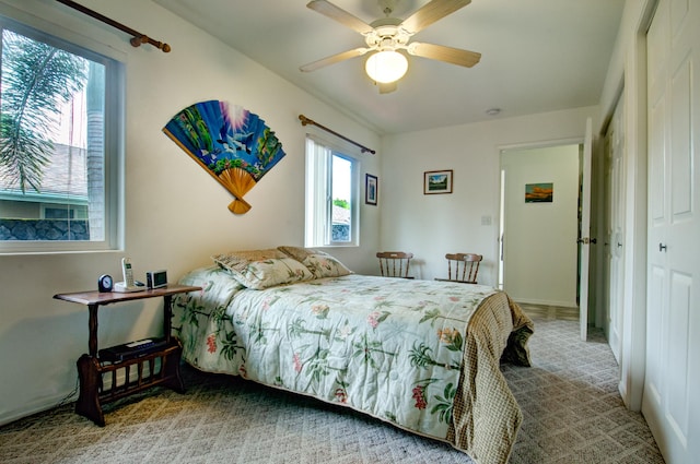 carpeted bedroom with ceiling fan and a closet