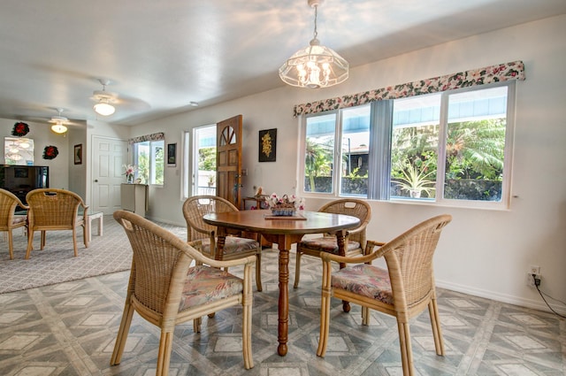 dining space with a healthy amount of sunlight and ceiling fan with notable chandelier