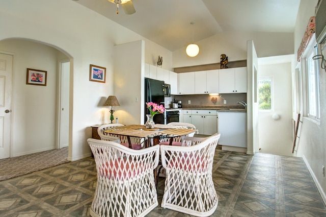 kitchen with white cabinets, vaulted ceiling, black refrigerator, backsplash, and dark parquet flooring