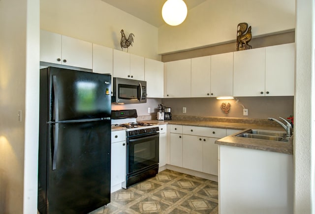 kitchen featuring white cabinets, black refrigerator, gas stove, and sink