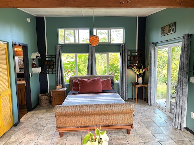 bedroom with multiple windows, a towering ceiling, and light tile patterned floors