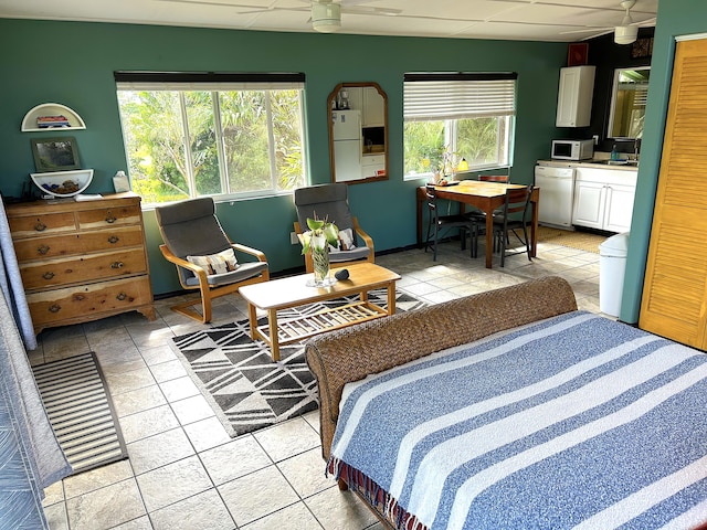 tiled bedroom featuring white refrigerator and a drop ceiling