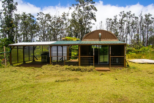 back of house featuring an outdoor structure and a lawn