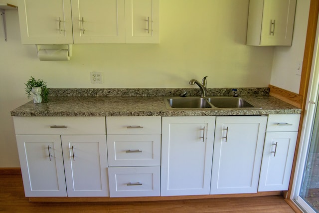 kitchen featuring dark wood-type flooring, sink, and white cabinetry