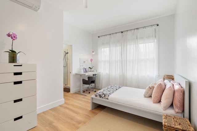 bedroom featuring a wall mounted air conditioner and wood-type flooring