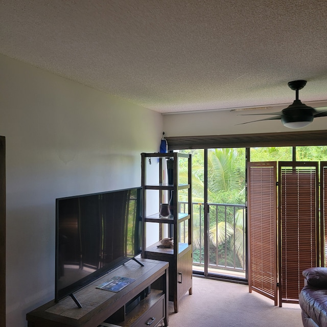 carpeted living room with a textured ceiling and ceiling fan