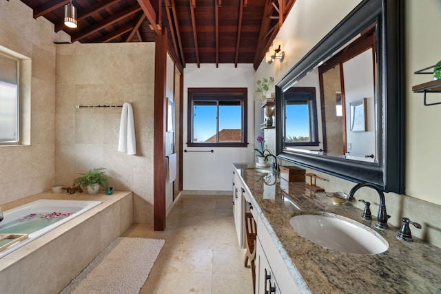 bathroom with wood ceiling, a washtub, vanity, and lofted ceiling with beams