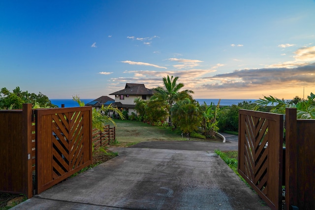 gate at dusk featuring a water view