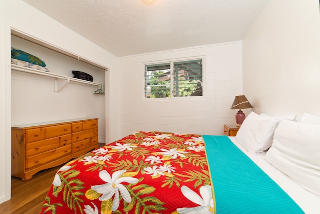 bedroom featuring a textured ceiling, a closet, and wood-type flooring