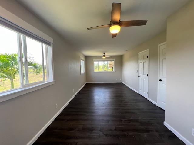 unfurnished room with ceiling fan and dark hardwood / wood-style flooring