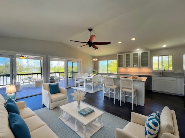 living room with ceiling fan, vaulted ceiling, dark wood-type flooring, and sink