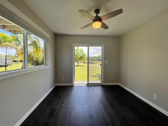 spare room with ceiling fan and dark hardwood / wood-style flooring