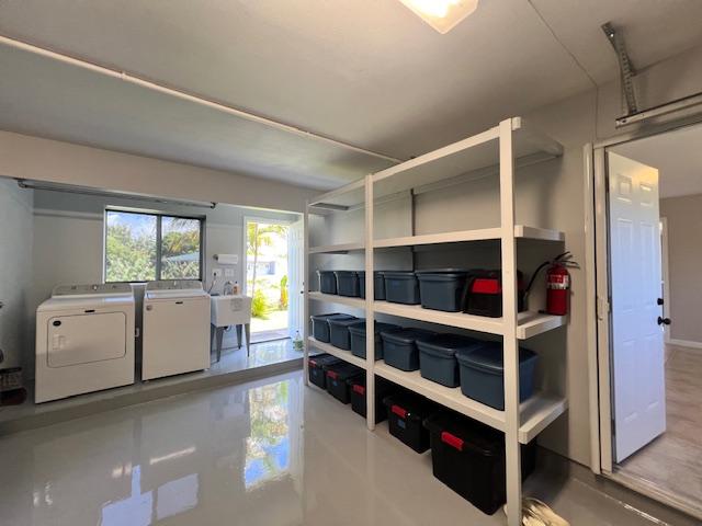 storage area with washer and dryer and sink