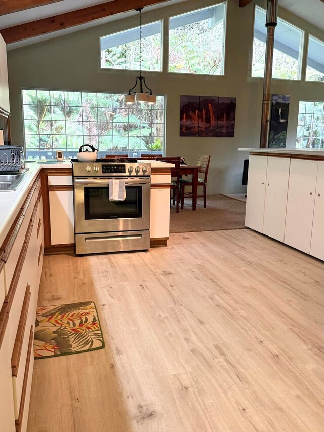 interior space featuring beam ceiling, a wood stove, and high vaulted ceiling