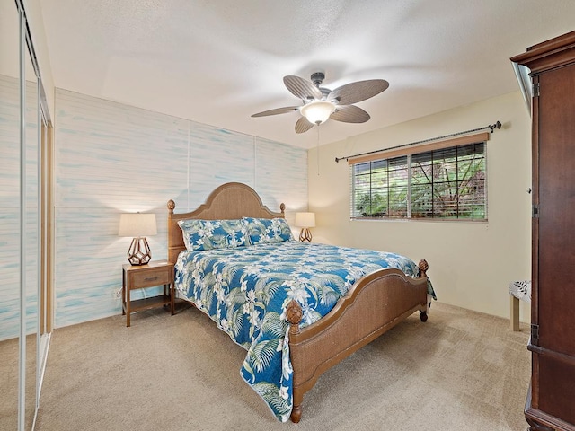 carpeted bedroom featuring a textured ceiling and ceiling fan