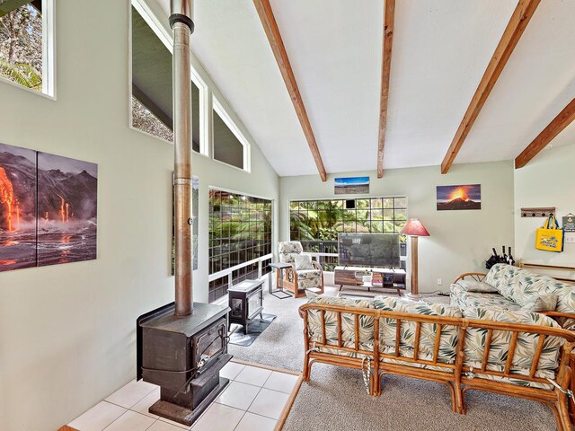 living room featuring high vaulted ceiling, light carpet, beam ceiling, and a wood stove