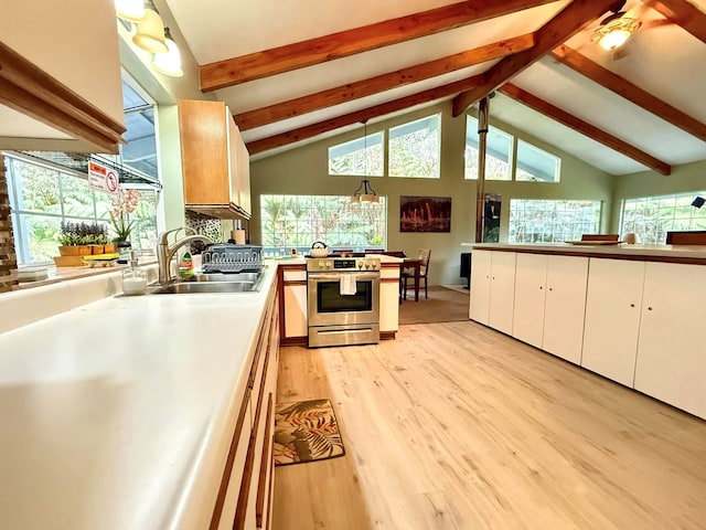 kitchen with sink, stainless steel stove, light hardwood / wood-style flooring, white cabinetry, and a wealth of natural light