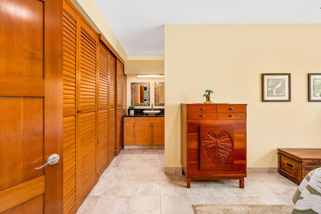 hallway featuring sink and light tile patterned floors