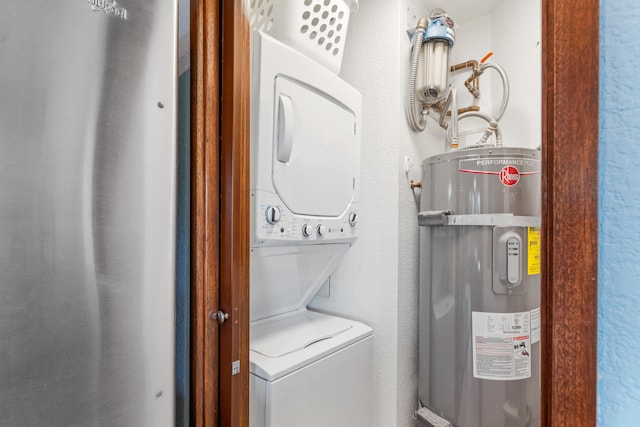 laundry area featuring stacked washer / drying machine and water heater