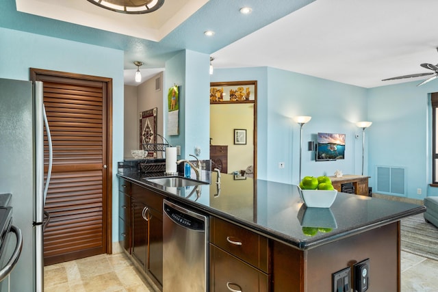 kitchen featuring appliances with stainless steel finishes, dark brown cabinets, ceiling fan, light tile patterned flooring, and dark stone countertops