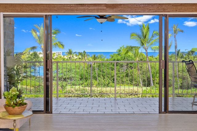 entryway with ceiling fan and a water view