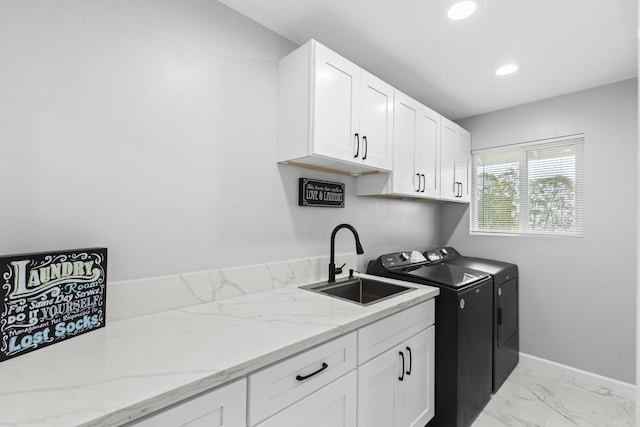 laundry area featuring cabinets, washer and clothes dryer, and sink