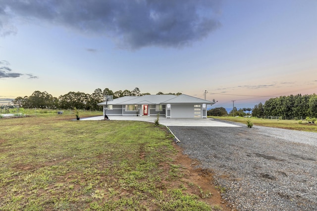 ranch-style house with a garage and a lawn