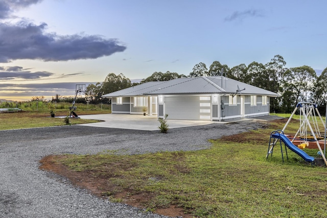 property exterior at dusk with a garage and a lawn