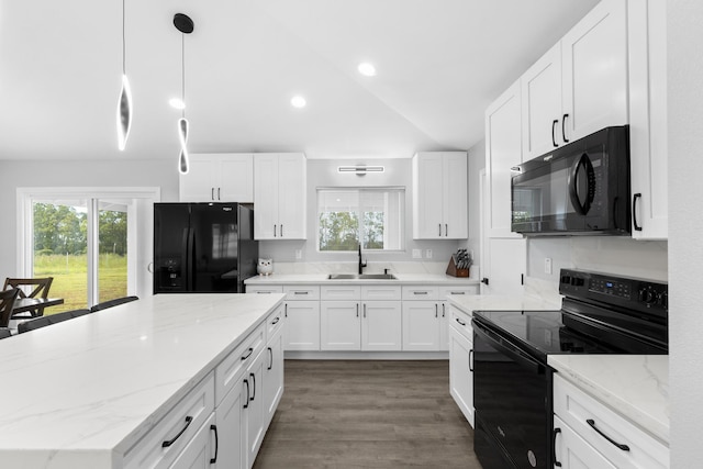 kitchen with pendant lighting, lofted ceiling, sink, white cabinets, and black appliances