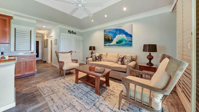 living room featuring wood-type flooring, ceiling fan, and crown molding