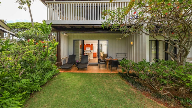 back of house with a patio area and a lawn