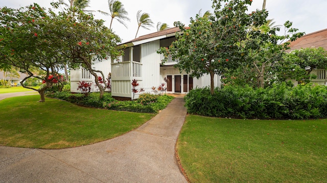 exterior space featuring a balcony and a front lawn