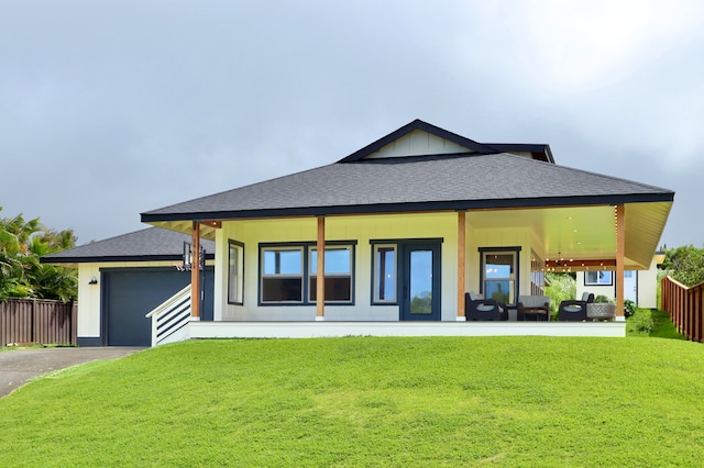 rear view of property with a garage and a lawn