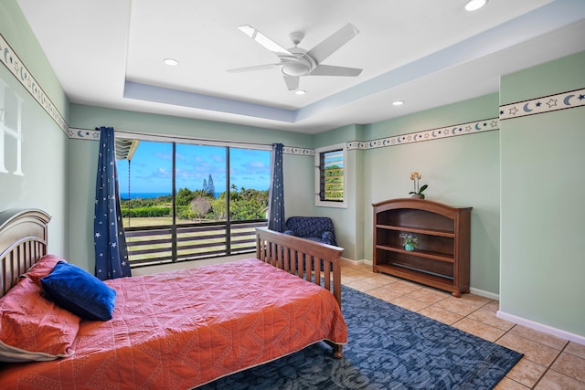 bedroom with ceiling fan, a raised ceiling, and light tile patterned floors