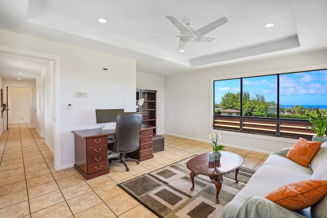 tiled office with ceiling fan and a tray ceiling