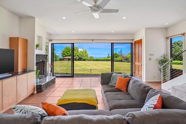 tiled living room with ceiling fan, plenty of natural light, and a high end fireplace