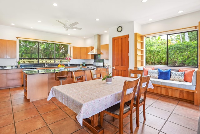 dining room featuring sink, ceiling fan, and light tile patterned flooring