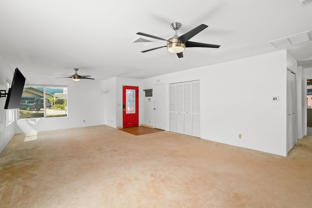 unfurnished living room featuring light carpet and ceiling fan