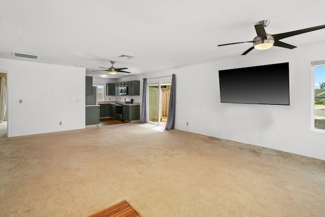 unfurnished living room featuring carpet flooring and ceiling fan