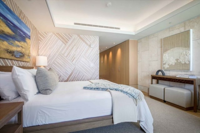 carpeted bedroom featuring a tray ceiling