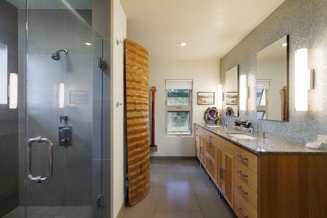 bathroom featuring vanity, an enclosed shower, tasteful backsplash, and tile patterned floors