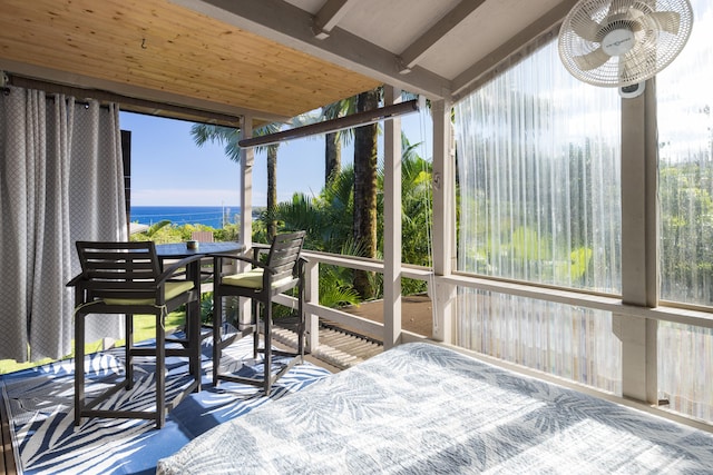 sunroom / solarium featuring a water view